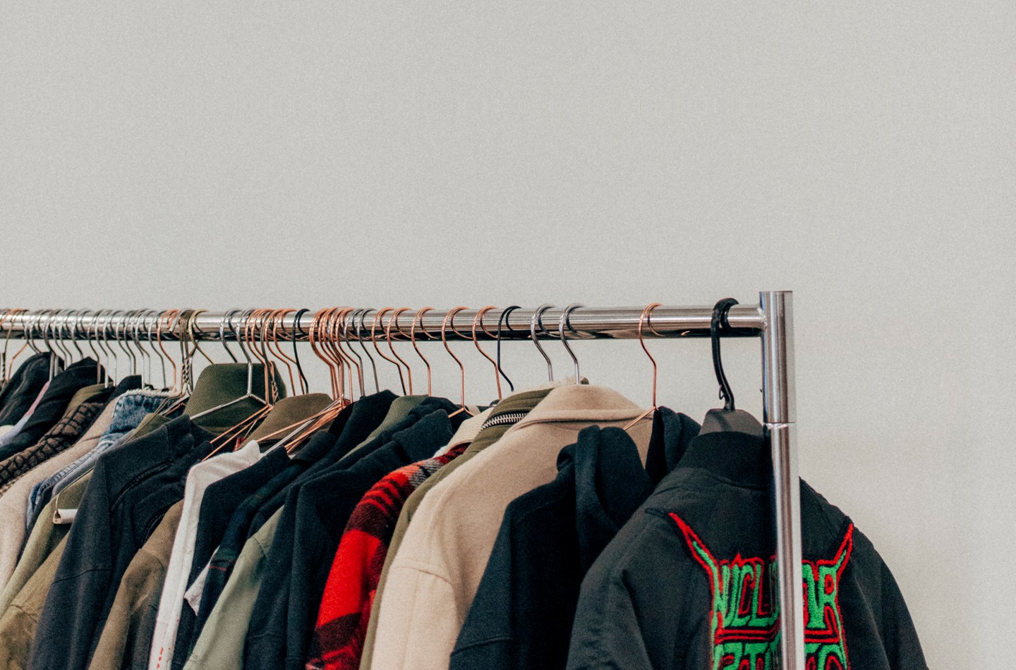 Rail of jackets and coats on copper hangers